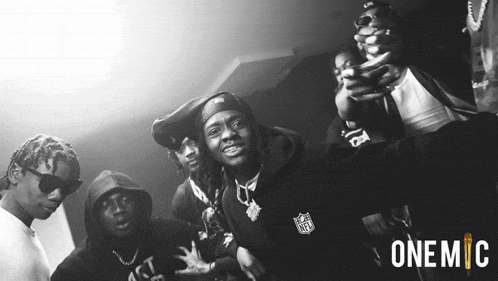 a black and white photo of a group of men with one wearing a nfl hoodie