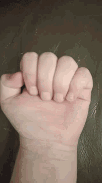 a close up of a person 's fist on a brown background
