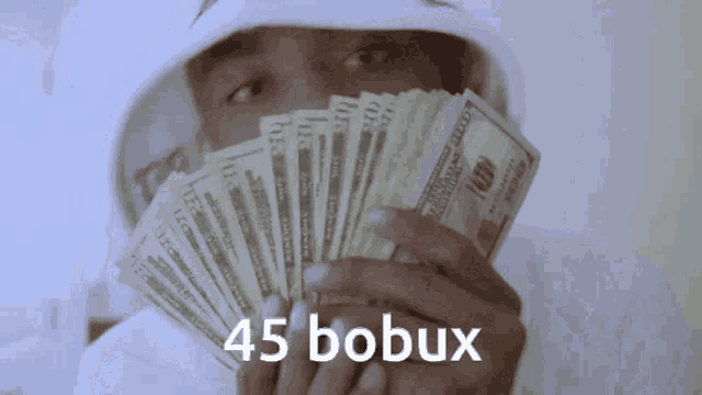 a man in a white hoodie is holding a fan of money with 45 bobux written on the bottom