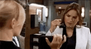 two women are standing next to each other in front of a mirror .