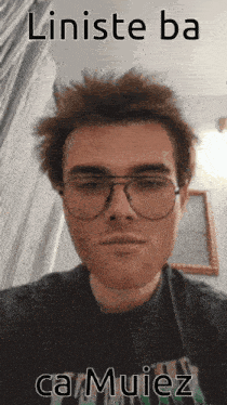 a man wearing glasses and a shirt that says camuiez looks at the camera