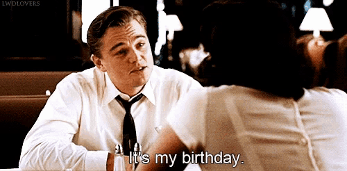 a man in a white shirt and tie is sitting at a table with a woman and says " it 's my birthday "