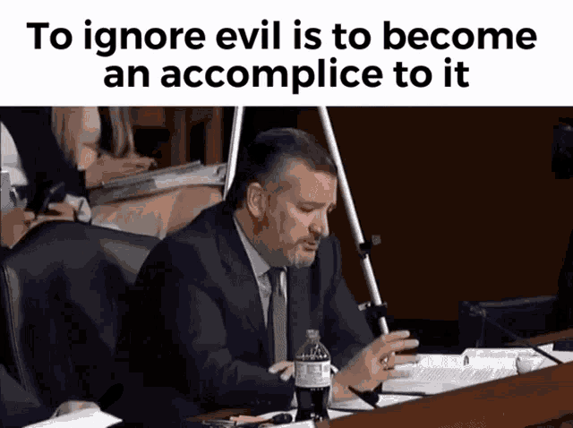 a man in a suit and tie is sitting at a desk with a coca cola bottle in front of him ..
