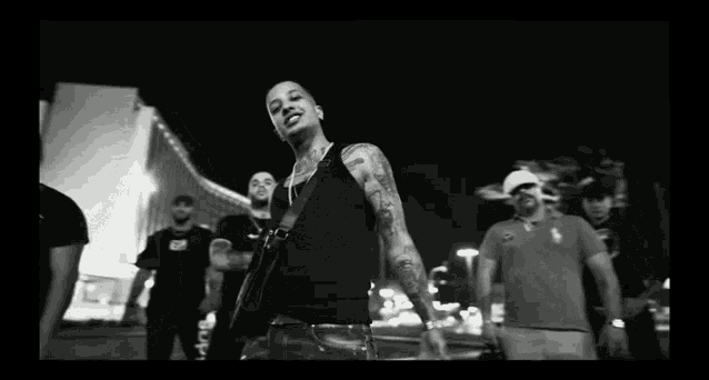 a black and white photo of a man with a tattoo on his chest