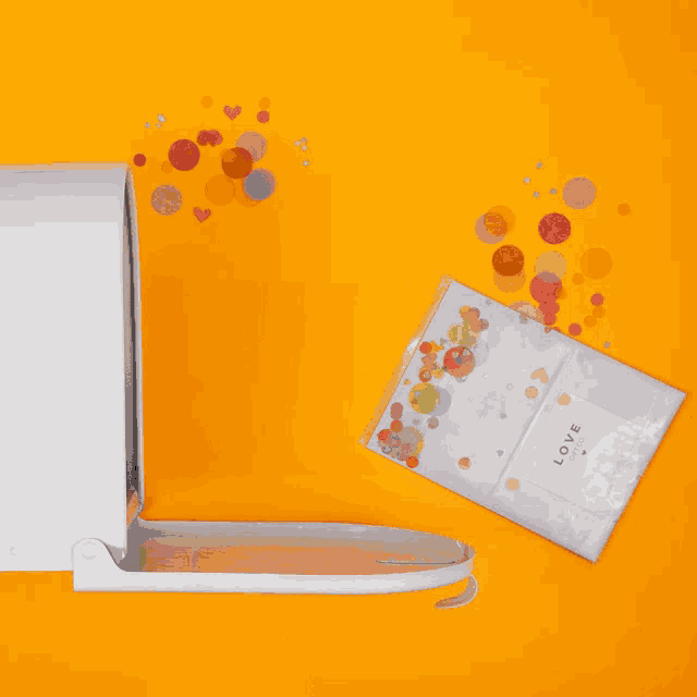 a white mailbox on an orange background with confetti flying out of it