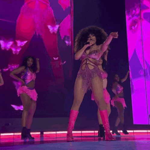 a woman with curly hair is singing into a microphone