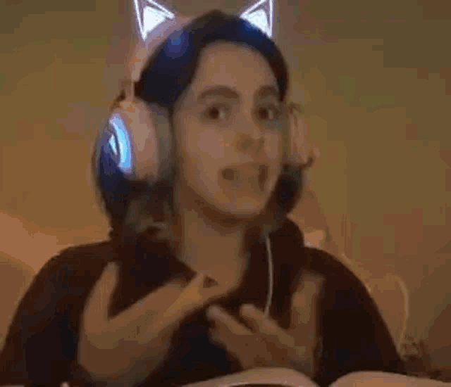 a woman wearing headphones is making a funny face while playing a video game .