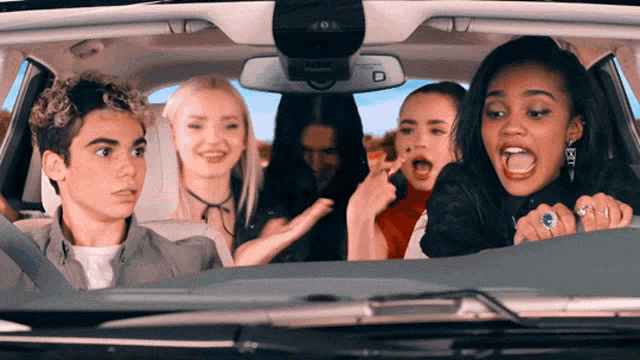 a group of people are sitting in a car and one of them has a ring on her finger that says bff