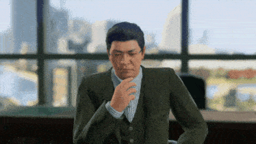 a man in a suit is sitting in front of a large window