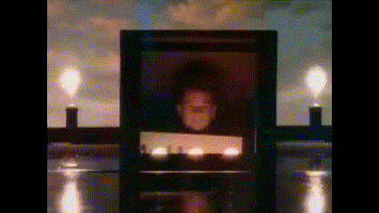 there is a picture of a man in a frame with candles in the background .