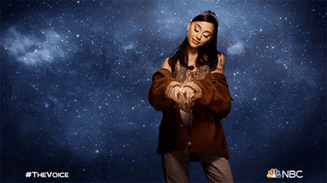 a woman in a brown jacket stands in front of a starry sky with the nbc logo visible