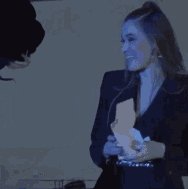 a man and a woman are standing in a dark room and the woman is smiling