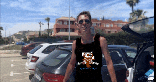 a man wearing sunglasses and a tank top with a bear on it