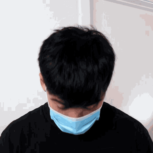 a man wearing a black shirt and a blue mask covering his face