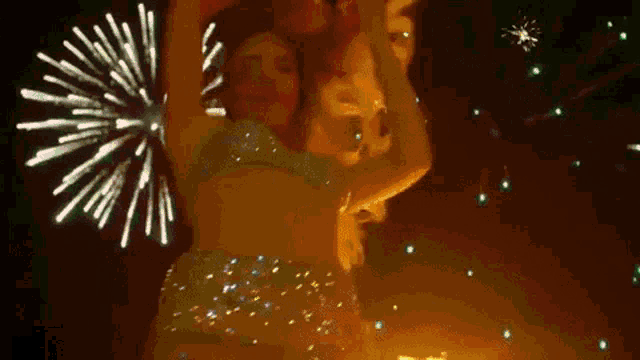 a woman is dancing in front of fireworks in the night sky .