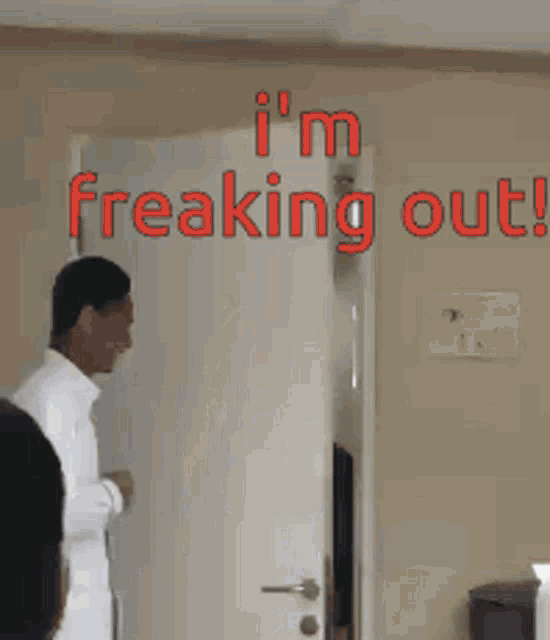 two men standing in front of a door with the words i 'm freaking out
