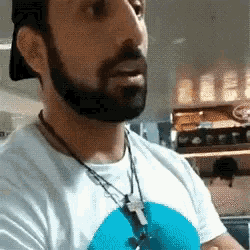 a man with a beard is wearing a hat and a white shirt