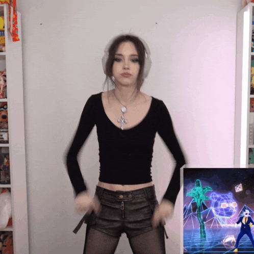 a woman wearing headphones is dancing in front of a picture of a man in a blue suit