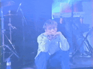 a man wearing a watch sits on the floor with his hands on his face