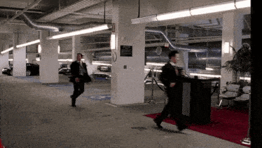 a man walking in a parking garage with a sign on the wall that says ' exit '