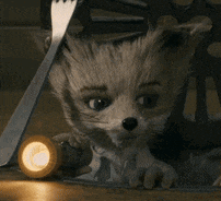a stuffed animal is hiding under a chair with a flashlight .