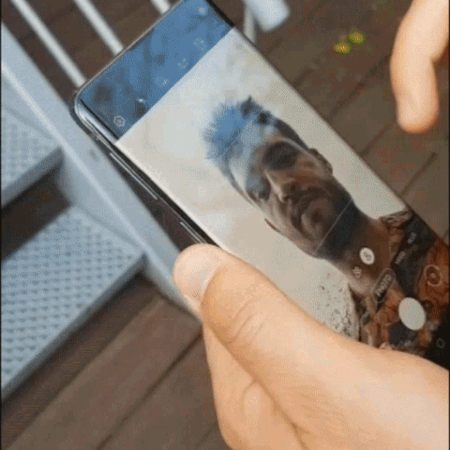 a person is taking a picture of a man 's face on their phone