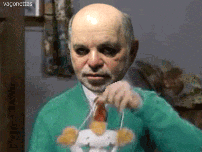 a bald man with a beard is wearing a green sweater