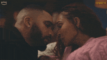 a man and a woman are kissing in front of a harlem sign