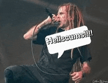 a man is singing into a microphone with a speech bubble above him .