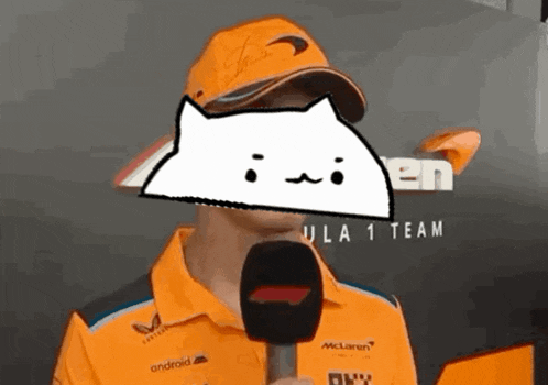 a man holding a microphone in front of a sign that says mclaren