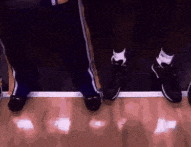 a group of people are standing next to each other on a wooden floor .