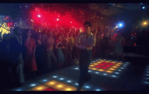 a blurred image of a crowd of people dancing in a club