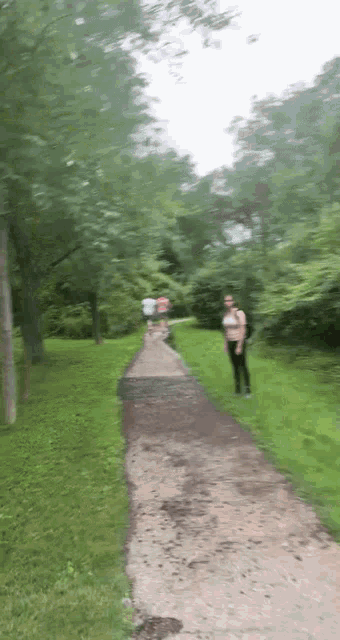 a blurry picture of people walking down a path in the woods