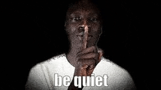 a man is making a silence sign with his finger to his mouth .