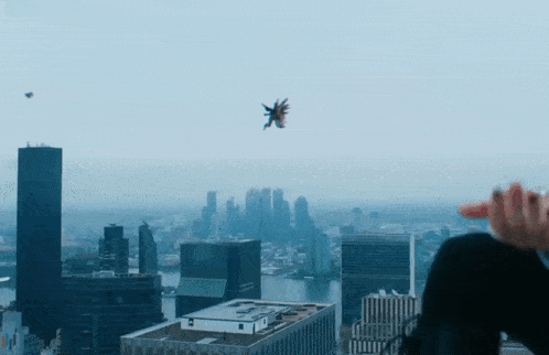 a person is looking at a city skyline with a helicopter flying overhead