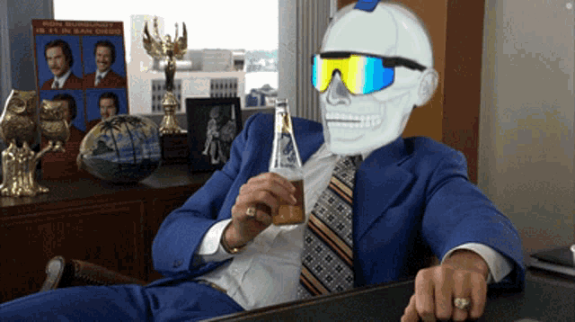 a man in a suit and tie is holding a beer