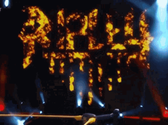 a wrestler is standing in front of a stage that says " reign " on it