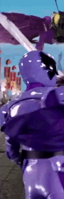 a purple robot with a sword is standing in front of a blue sky