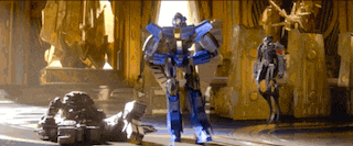 a robot is standing next to a statue of a man in a room .
