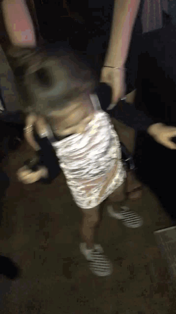 a blurry picture of a woman in a white dress and striped shoes