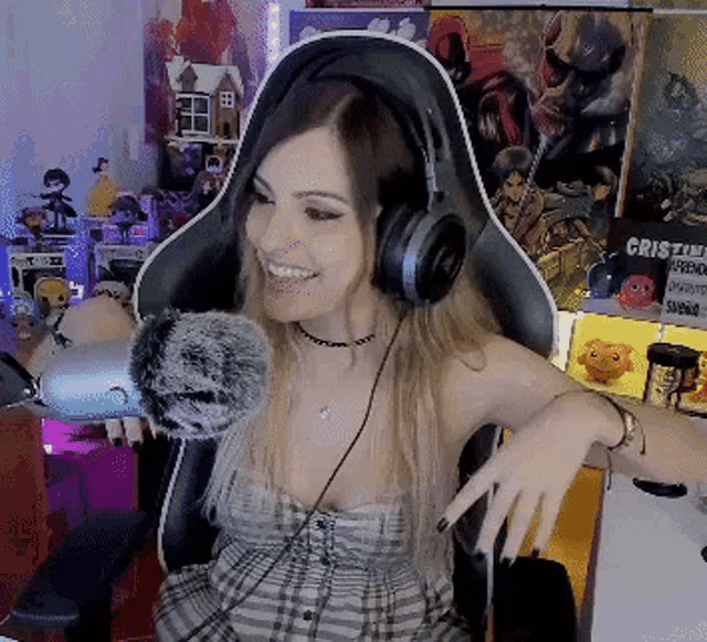 a woman wearing headphones and a plaid dress is sitting in a chair