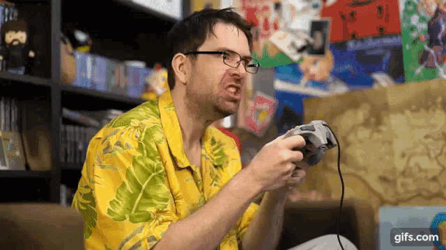 a man in a yellow shirt is playing a video game with a controller .
