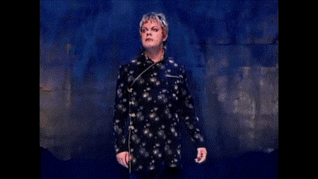 a woman singing on a stage with the words " and i 'm backing it up with this gun "