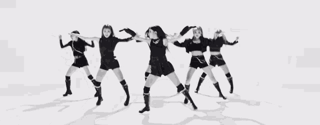 a black and white photo of a group of women dancing together .
