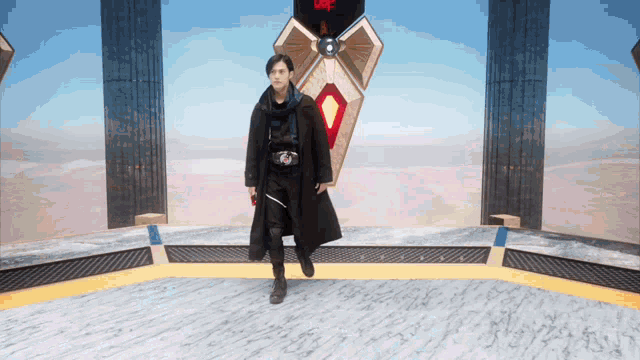a man in a black coat is walking in a room with a sign that says ' i love you ' on it