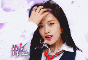 a woman in a white shirt and tie holds her hand to her forehead in front of a sign that says ivz