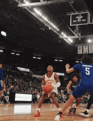 a basketball player with the number 14 on his jersey is holding the ball