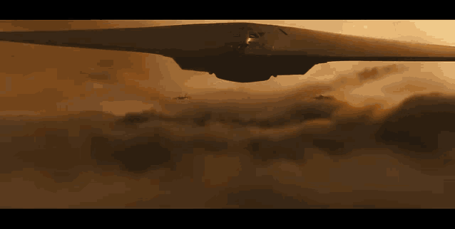 a large jet is flying through the clouds