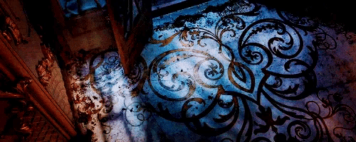 a dark room with a blue pattern on the floor