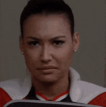 a close up of a woman making a funny face while sitting in a chair .